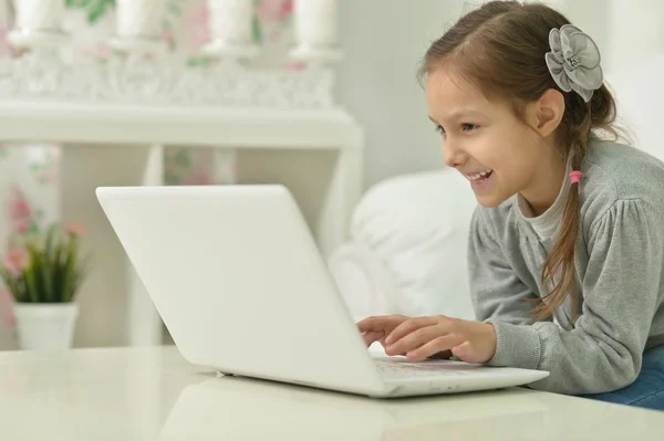 Smiling little girl with laptop computer — Stock Photo, Image