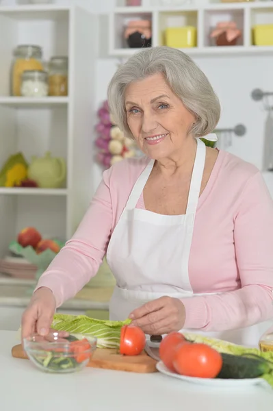 Senior woman cooking in kitchen — Stock Photo, Image