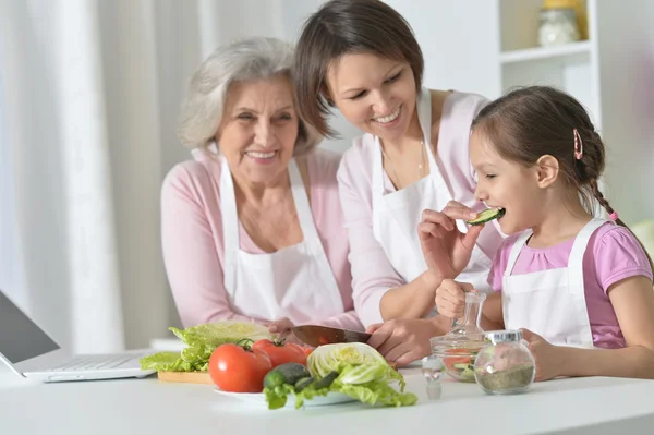 Kvinnor med liten flicka matlagning — Stockfoto