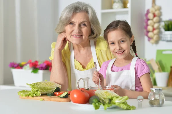 Senior vrouw met kleindochter koken — Stockfoto