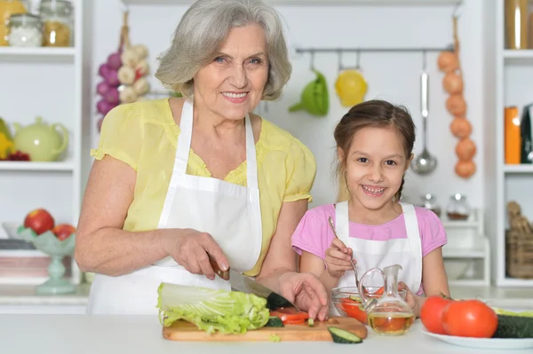 Äldre kvinna med barnbarn matlagning — Stockfoto