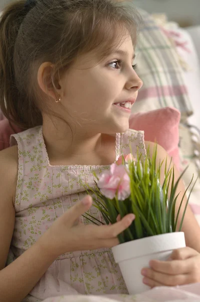 Kleines Mädchen posiert mit Blumen — Stockfoto