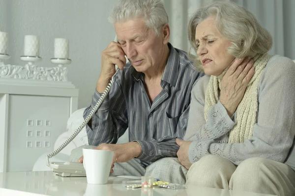 Zieke bejaarde echtpaar met telefoon — Stockfoto