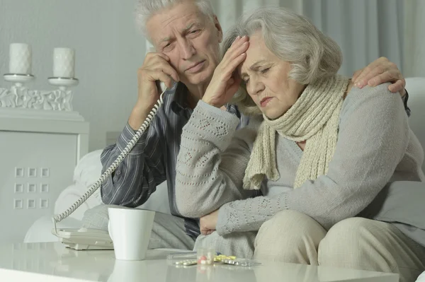 Sjuka äldre par med telefon — Stockfoto