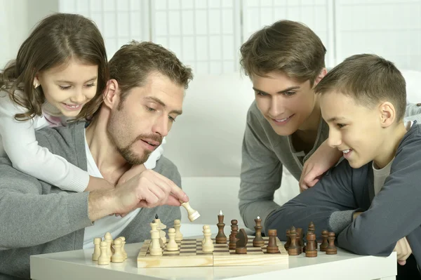 Família jogando xadrez em casa — Fotografia de Stock