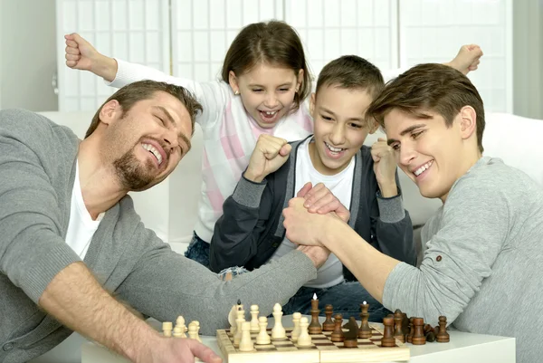 Семья играет в шахматы дома — стоковое фото