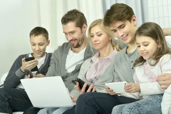 Famille heureuse avec gadgets électroniques — Photo