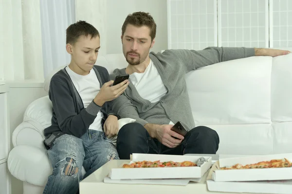 Pai e filho com pizza e smartphone — Fotografia de Stock