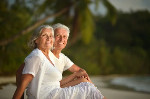 Elderly couple rest at tropical beach — Stock Photo, Image