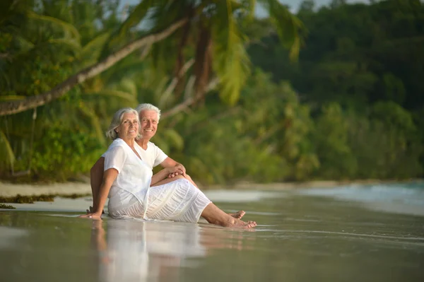 Casal de idosos descansam na praia tropical — Fotografia de Stock