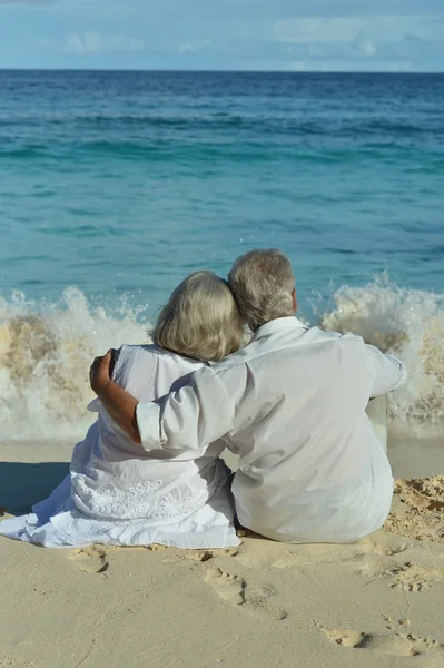 Elderly couple rest at tropical beach — Stock Photo, Image