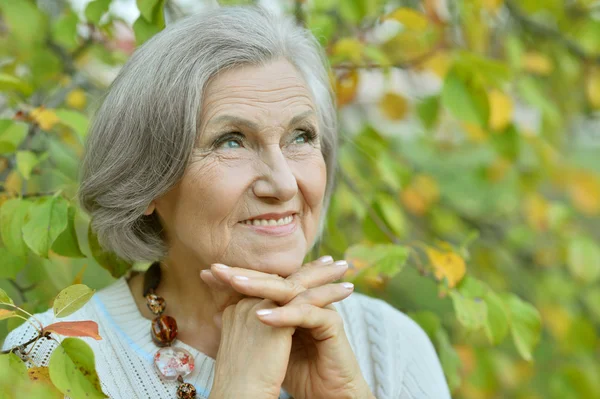 Senior woman in green park — Stock Photo, Image