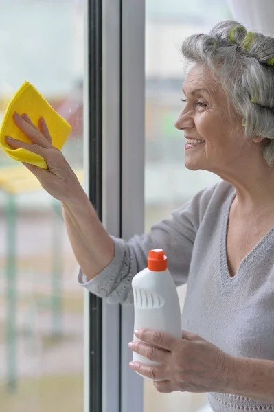 Senior woman cleaning window — Stock Photo, Image