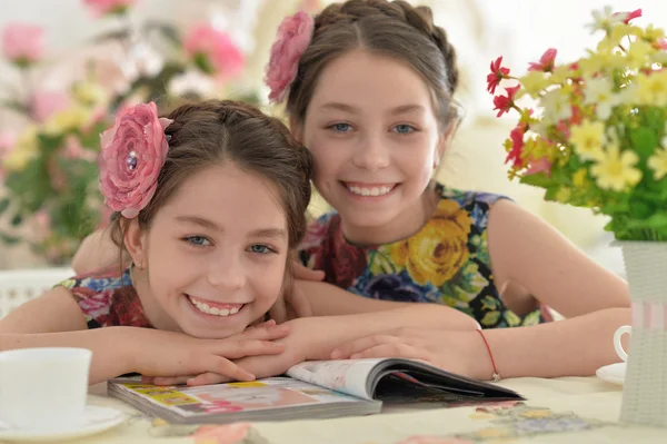 Två små flickor i blommiga klänningar — Stockfoto