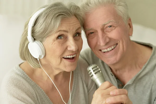Starší pár s sluchátka — Stock fotografie