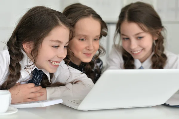 Drie kleine meisjes met behulp van een laptop — Stockfoto