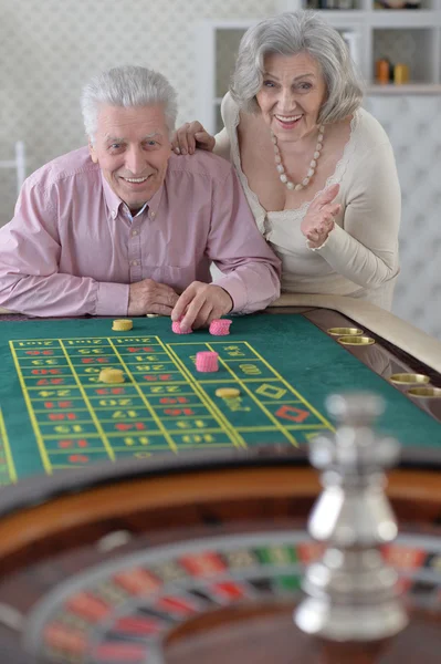 Старшая пара с фишками казино — стоковое фото
