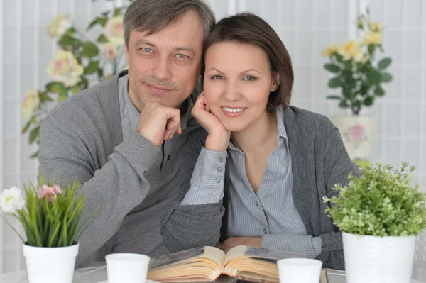 Pareja sonriente sentada en la mesa —  Fotos de Stock