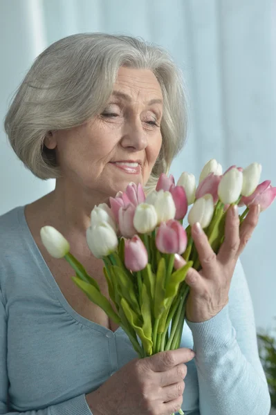 Seniorin mit blühenden Blumen — Stockfoto