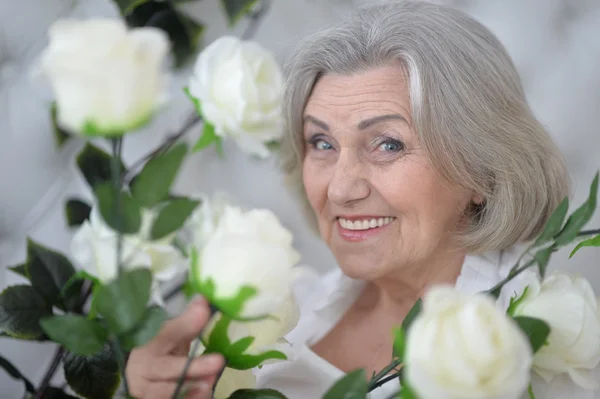 Mulher sênior com flores florescendo — Fotografia de Stock