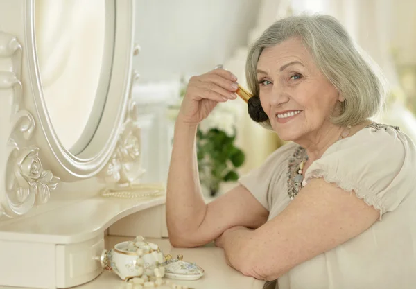 Senior woman with make up brush — Stock Photo, Image