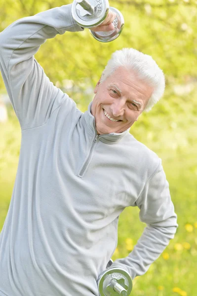 Älterer Mann trainiert mit Hanteln — Stockfoto