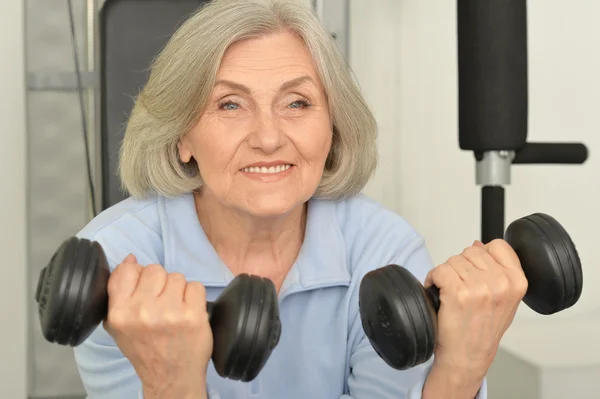 Elderly woman exercising in gym — Stock Photo, Image