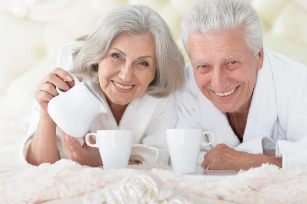 Senior echtpaar in bed met thee — Stockfoto