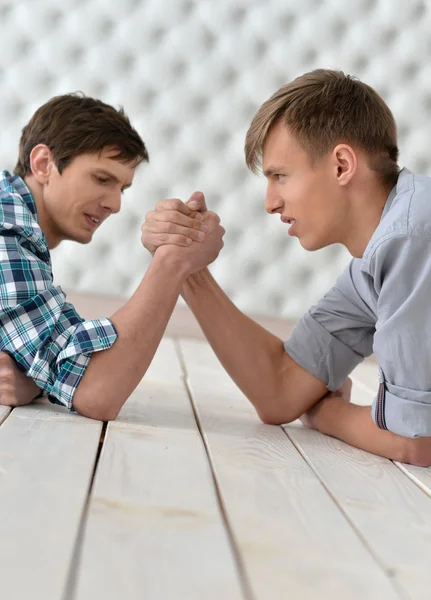 Men  at the table and armwrestling — Stock Photo, Image