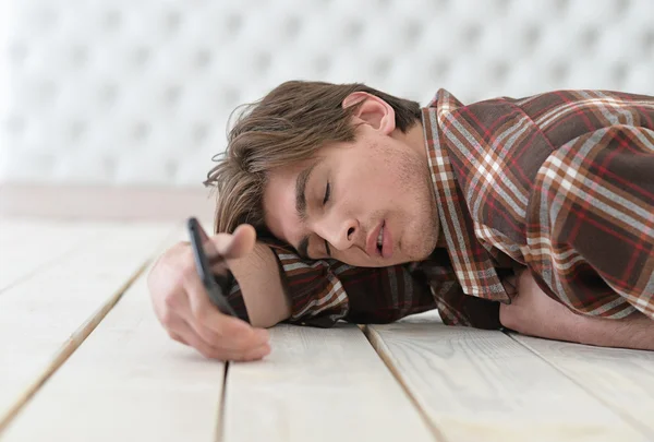 Jovem dormindo com telefone — Fotografia de Stock