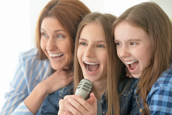 Madre e hijas cantando karaoke — Foto de Stock