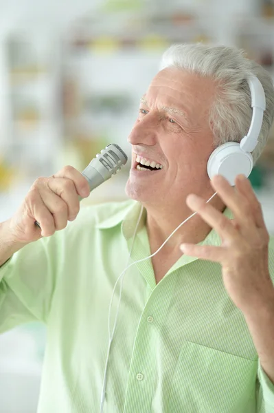 Senior mit Kopfhörern singt — Stockfoto