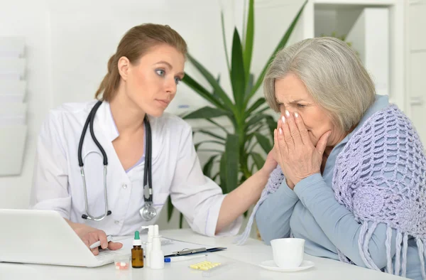 Junge Ärztin und ihr älterer Patient — Stockfoto