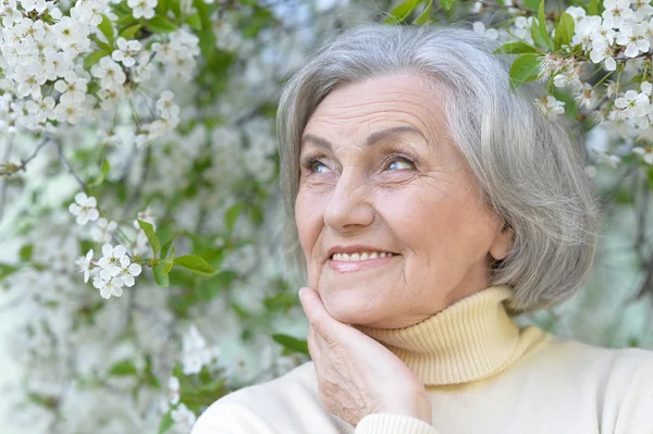 Äldre kvinna med blommor — Stockfoto