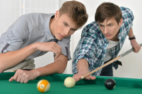Young men playing billiards Royalty Free Stock Photos