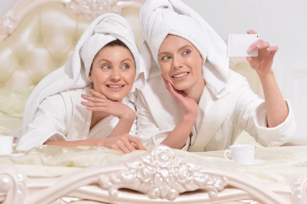 Vrouwen in badjassen doen selfie — Stockfoto