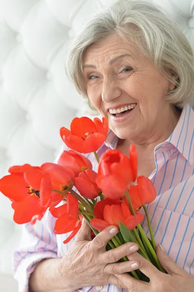 Senior woman with blooming poppies — Stock Photo, Image