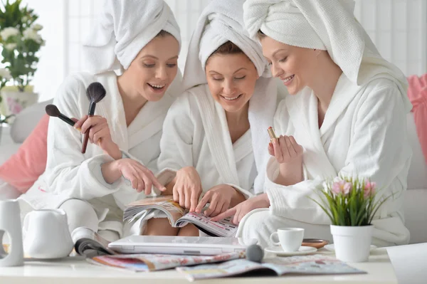 Kvinnor i vita badrockar med tidskrift — Stockfoto