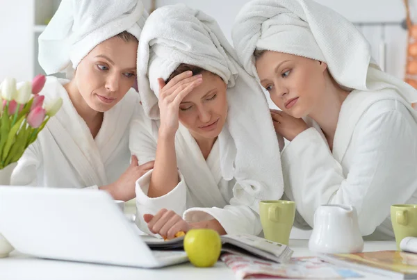 Mujeres con albornoces blancos con portátil — Foto de Stock