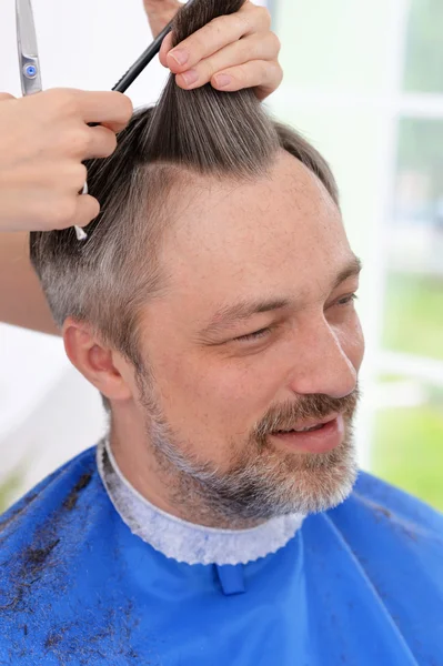 Мужчина, стригущийся у парикмахера — стоковое фото