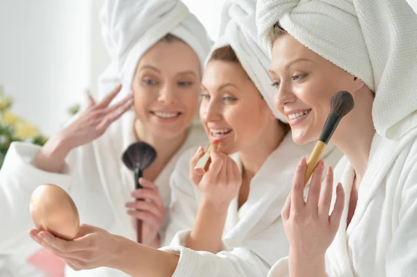 Junge Frauen in weißen Bademänteln — Stockfoto