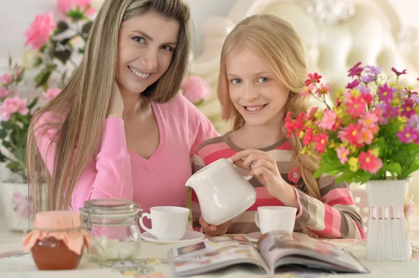 Madre con hija pequeña con revista —  Fotos de Stock