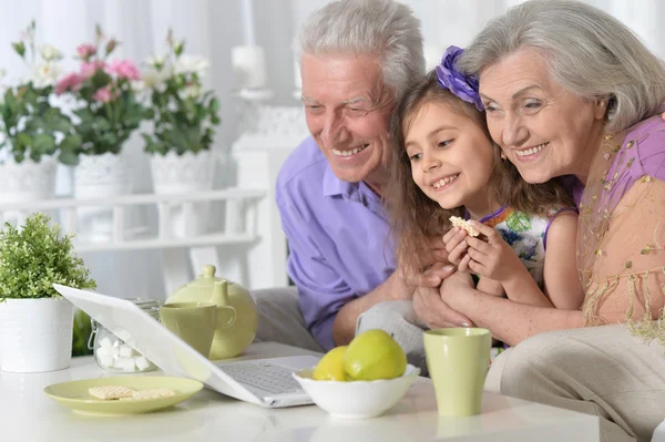 Großeltern und kleines Mädchen mit Laptop — Stockfoto