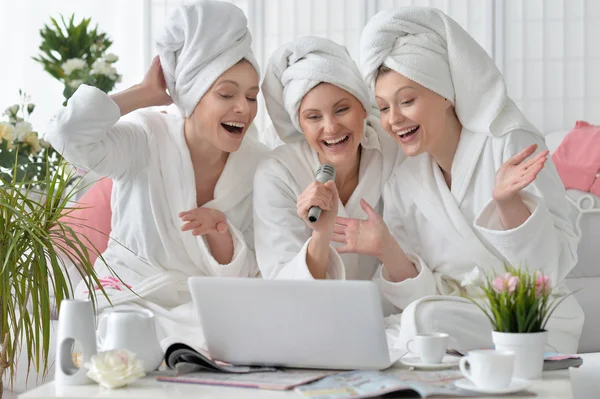 Vrouwen in witte badjassen zingen met microfoon — Stockfoto