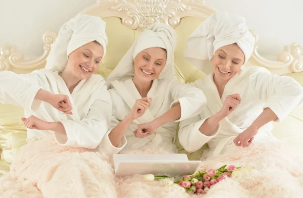 Mujeres con albornoces blancos con portátil — Foto de Stock