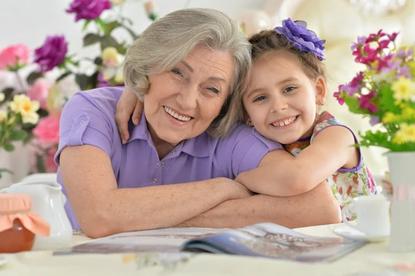 Vrouw met meisje lezing magazine — Stockfoto