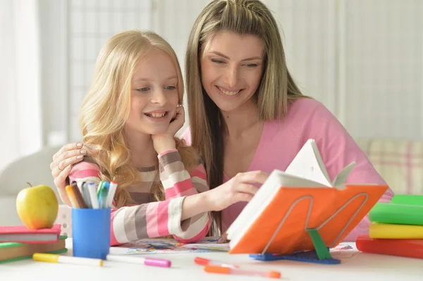 Moeder haar dochter helpen met huiswerk — Stockfoto