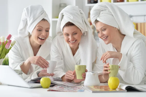 Mujeres con albornoces blancos con portátil —  Fotos de Stock