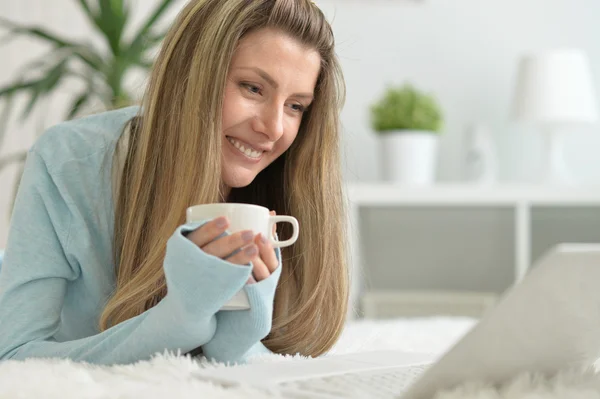Усміхнена жінка п'є чай — стокове фото
