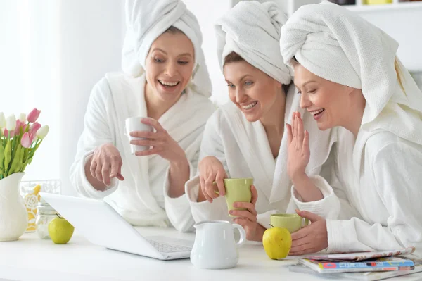 Women wearing a white bathrobes with laptop — Stock Photo, Image